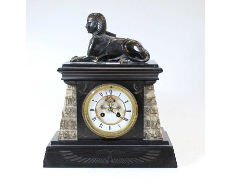 A late Victorian black slate mantel clock, decorated in the Egyptian style, having an enamelled chapter ring, with Roman nume