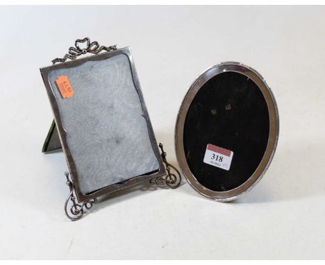 A late Victorian silver clad easel photograph frame, of rectangular form, surmounted by a ribbon and with pierced supports, m