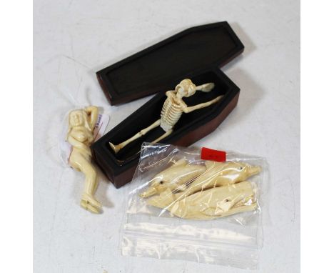 A miniature model of a skeleton in mahogany coffin, length 12.5cm, together with figure of a female nude and three carved fig