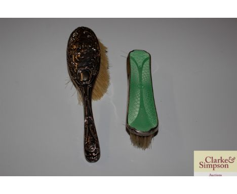 A silver backed hair brush with cherub decoration and a white metal and enamel backed brush