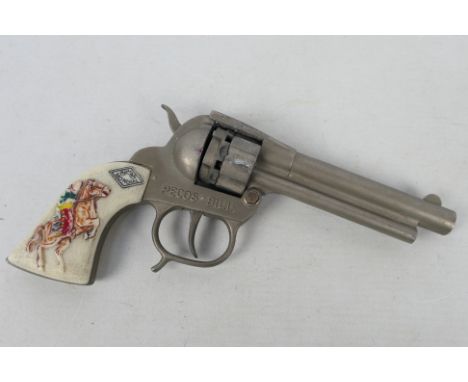 Mondial - A vintage Mondial Pecos Bill cap gun with white plastic hand grips with horse and rider on. It has some light corro