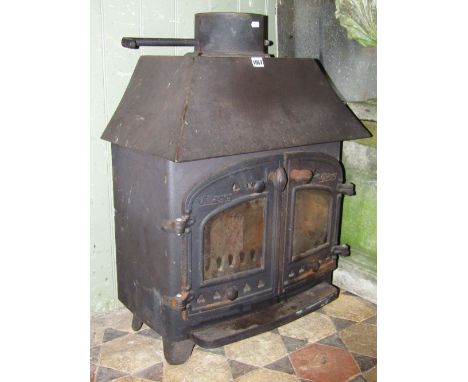 A Villager cast iron wood burning stove, enclosed by a pair of arched and glazed panel doors with pierced tre-foil detail