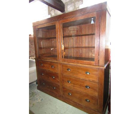 A substantial pitch pine dresser, the upper section enclosed by a pair of rectangular glazed panelled doors revealing two fix