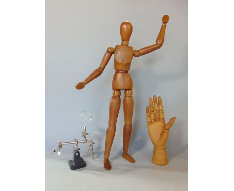 An artists dummy with articulated limbs together with a further artists hand dummy with articulated fingers and a magnifying 