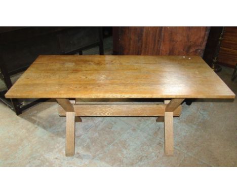 A light oak tavern type table, the rectangular top raised on a pair of X framed supports united by a central stretcher, 153cm