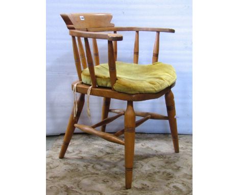 A light elm and beechwood smokers bow elbow chair with turned spindle back, raised on tapered partially ring turned supports 