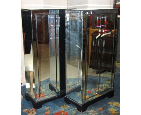 A pair of contemporary side cupboards, freestanding and enclosed by a pair of full length doors, with bevelled edge mirror pa