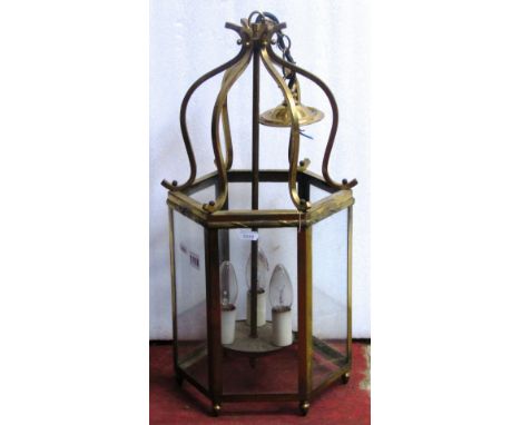 A Georgian style hanging porch lantern of hexagonal form, with brass frame, enclosing glazed panels and central stem supporti