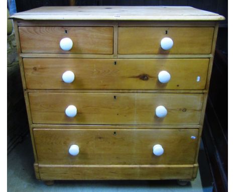 A Victorian stripped pine bedroom chest of two short over three long graduated drawers with ceramic handles and turned bun su