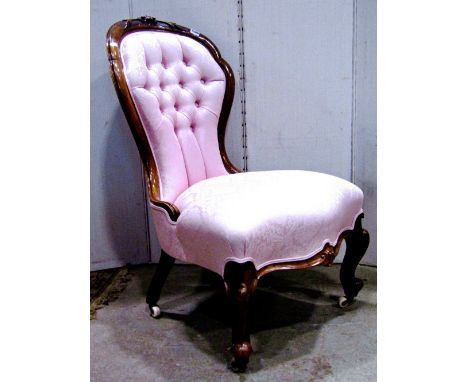 A Victorian drawing room chair, with light pink floral patterned upholstered seat, buttoned back and arms, within a walnut sh