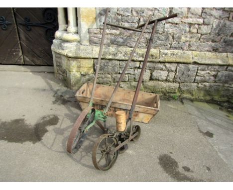 A vintage Planet Junior push hoe, with ashwood handle, together with a seed drill with two spoke wheels and a tapered rectang