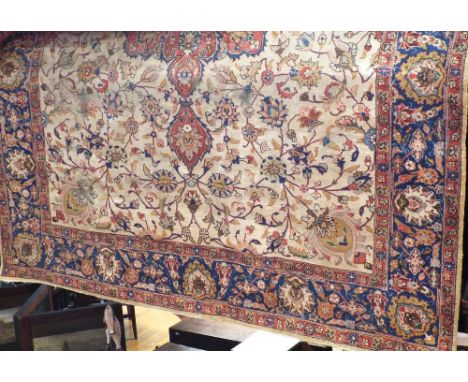 Indian carpet with central floral red medallion, framed by scrolled foliage, upon a fawn ground, 350 x 280cm