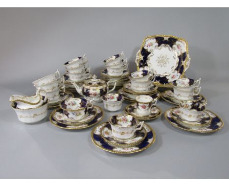 A quantity of early 20th century Coalport teawares with floral decoration on a blue and gilt ground, comprising pair of cake 