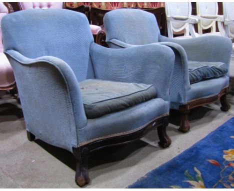 A pair of Georgian style low easy chairs with swept arms, serpentine seat, light blue ground upholstery, raised on scrolled f