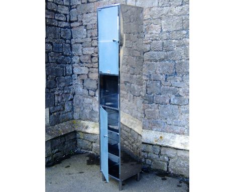 A modern floorstanding stainless steel framed bathroom storage cabinet, partially enclosed by two frosted glass doors, togeth