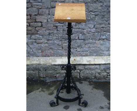 A good quality ecclesiastical floorstanding lecturn with light oak rest, raised on a wrought iron stand with partially twiste