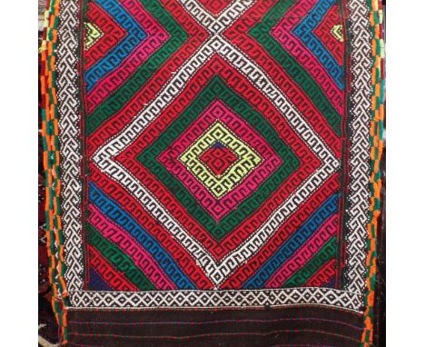 A colourful Kelim runner with geometric medallion pattern upon a dark ground, 300 x 70cm