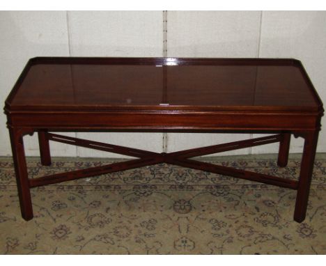 A reproduction Georgian style mahogany occasional table of rectangular form with moulded tray top and supports united by a pi