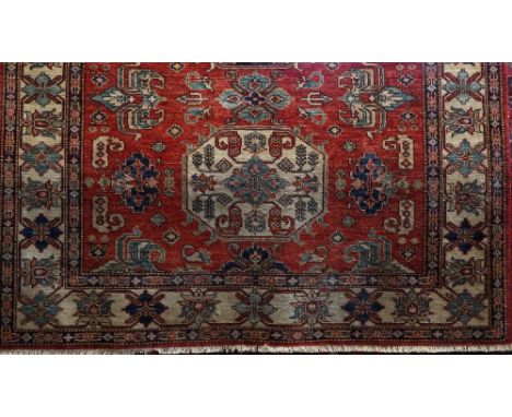 A good quality Persian wool carpet, the hexagonal blue medallion centre upon a red field with repeating geometric detail with