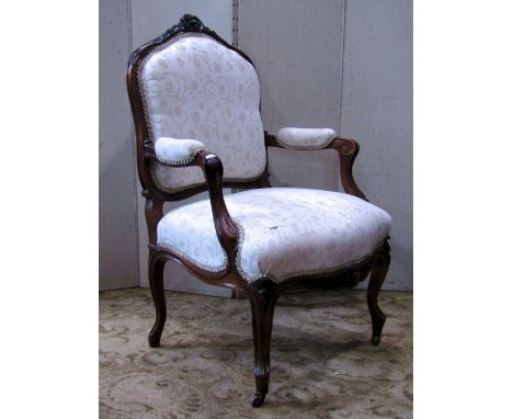 A 19th century fauteuil with cream ground floral patterned upholstered sprung seat and padded shield shaped back, within a sh