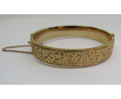 9ct hinged bangle with scrolled decoration, 12.8g
