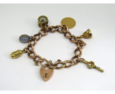 Antique 9ct curb link charm bracelet with heart padlock clasp, hung with an 1898 half sovereign, 9ct seal and four further ye