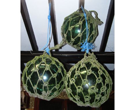 Three large vintage green tinted hand blown rope twist encased fishing floats 18 inches in diameter approx