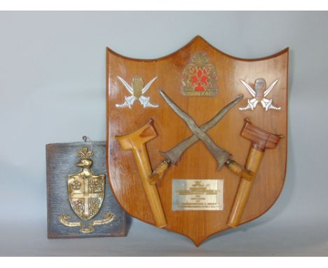 A shield shaped panel supporting two Krists and scabbards, presentation plaque inscribed 'Presented by the First Federation R