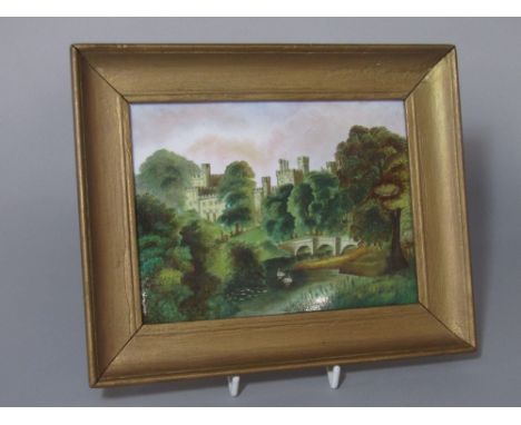 A 19th century ceramic panel of rectangular form with painted decoration of a multi turreted castle viewed from a river with 