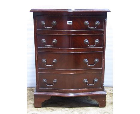 A small reproduction Georgian style chest with serpentine front fitted with four long drawers raised on bracket shaped suppor