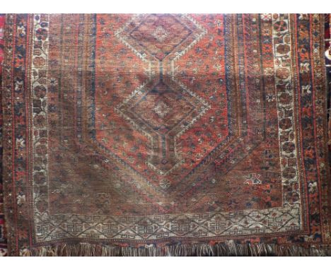 Shiraz carpet with triple pole medallion decoration upon a red ground, 250 x 195cm