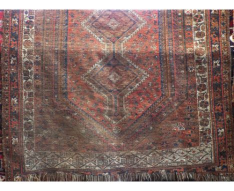 Shiraz carpet with triple pole medallion decoration upon a red ground, 250 x 195cm