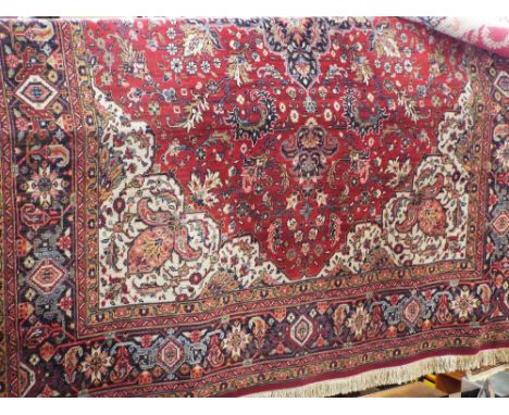 Axminster 'Sharabian' carpet with intricate floral decoration and central blue medallion upon a red ground, 350 x 250cm