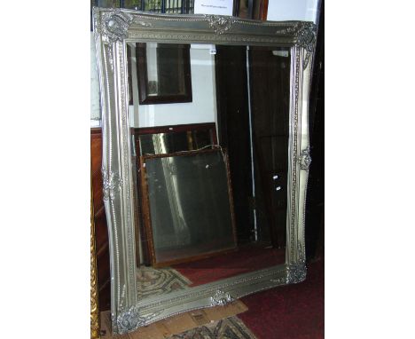 A large contemporary reproduction wall mirror of rectangular form with bevelled edge plate, set within a swept and moulded fr