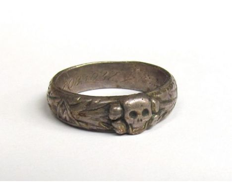 A German white metal ring with scull and swastika design, inscribed 08.10.42