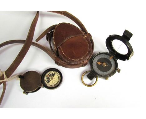 A WWI British marching compass dated 1917 No. 75067 together with 1917 dated leather case and another swivel-action compass 