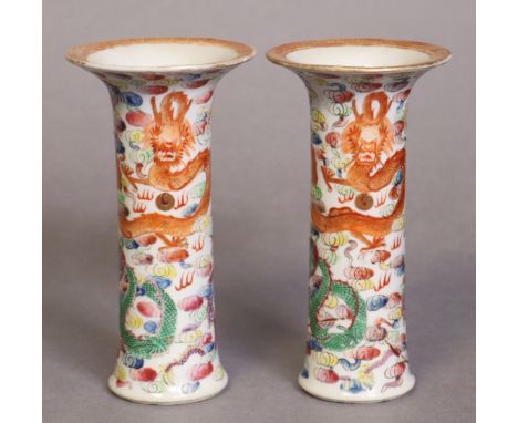 A pair of early 20th century Chinese porcelain small sleeve vases, each painted in famille rose enamels dragons chasing the f
