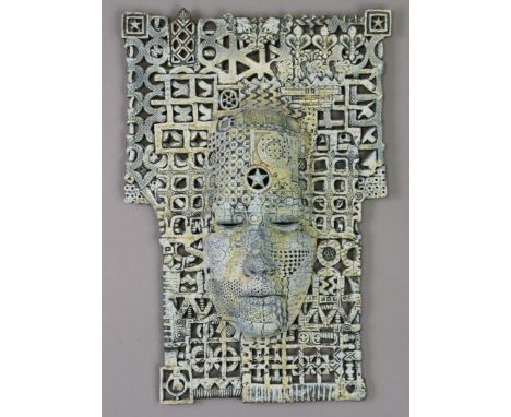 ALASDAIR NEIL MACDONELL (b. 1947) a ceramic wall mask with blue glaze, on a shaped rectangular flat ground with intricate pie