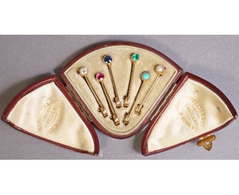 A set of six multi-gem &amp; yellow metal bar brooches of safety pin form, each set a single diamond, ruby, sapphire, emerald