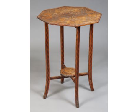 An early 20th century poker work table, the octagonal top with drop leaves, on folding supports, all-over carved with grape v