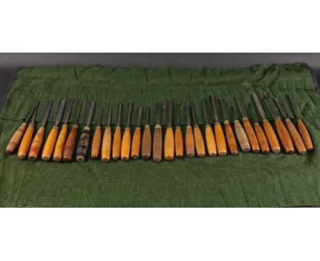 A collection of tweny eight vintage wood working steel gouges, with wooden handles, some ring turned, all with brass collars,