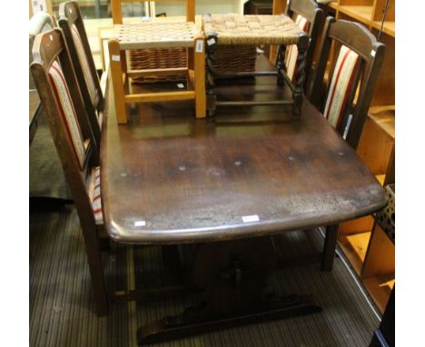 A dark oak Ercol dining table of trestle design with a set of four Edwardian dining chairs