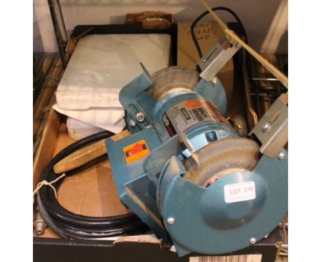 A box containing a bench grinder and other tools