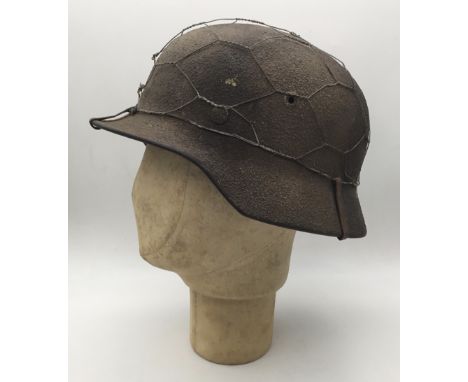 A WW2 era German M40 rough textured or ‘Zimmerit’ combat helmet, marked Q64 for the manufacturer of Quist, Esslingen. Featuri