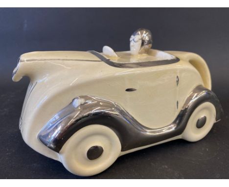 An Art Deco cream glazed teapot in the form of a stylish racing car, impressed registration number to the base. 