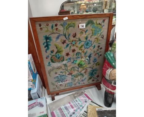 A vintage oak framed fire screen with wool work tapestry centre