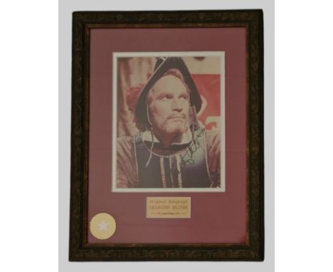 Charlton Heston signed colour photo from his role as Robert Devereux in the 1968 movie Elizabeth the Queen. Mounted and frame