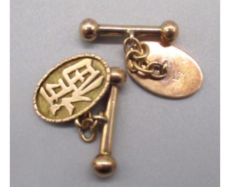 Pair of 14ct yellow gold oval cufflinks, the faces decorated with Chinese character marks, with chain and toggle back, stampe