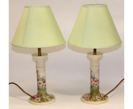 Moorcroft Pottery: pair of Spring Blossom pattern candlestick form table lamps, tube lined decoration of pink flowers on grad