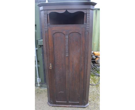 C20th oak arts and crafts style hall corner wardrobe with carved floral motifs, open shelf above panelled door revealing 3 sh